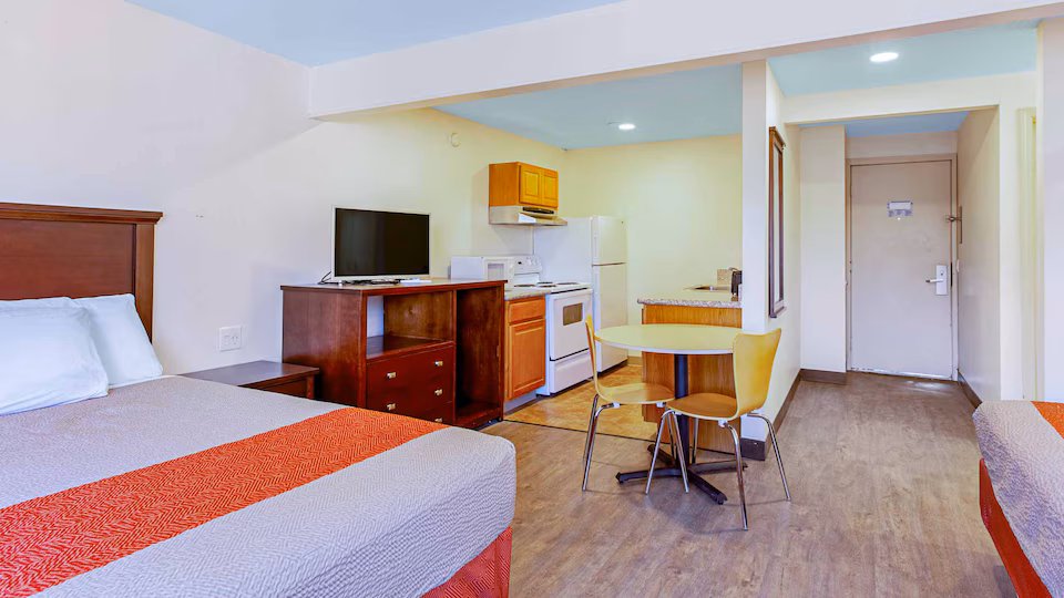Kitchenette, dining table, and sleeping area in the three-queen room